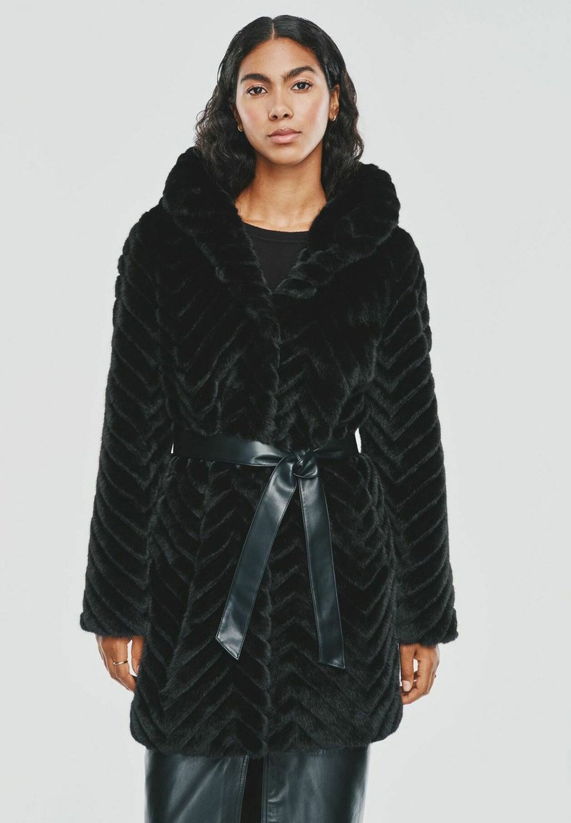Czarny płaszcz z sztucznego futra z wzorem w zygzak, dużym kołnierzem i błyszczącym czarnym paskiem. Długie rękawy o luźnym kroju.
