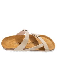 Ljusbeige sandal med korsremdesign, justerbart metallspänne, mjukt mockainlägg och texturerad gummisula.