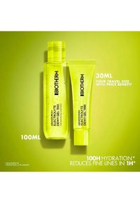 Dos botellas de gel hidratante Biotherm Aquasource Electrolyte Dewy, de 100 ml y 30 ml, sobre fondo verde con textos que indican hidratación y anti-envejecimiento.