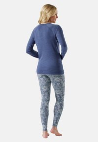 Long-sleeve blue shirt with a round neckline, paired with patterned leggings featuring a blue and white geometric design.