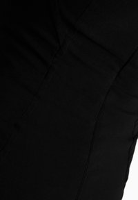 Černá tkanina s hladkým povrchem, obsahující detaily švů a subtílní švy. Design zdůrazňuje přiléhavý tvar.