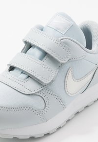 Sneakers Nike azzurri chiari con le strisce in velcro, dotati di tomaia in tessuto testurizzato, dettagli in pelle liscia e logo swoosh bianco.
