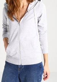 Grauer Kapuzenpullover mit Reißverschluss, Kängurutasche, verstellbarer Kapuze mit Kordelzug, gerippten Bündchen und weicher Baumwollmischung.