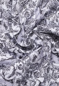 Zwart-witte stof met ingewikkelde bloemen- en dierenpatronen, met een gladde textuur en een soepele val, die gedetailleerd lijnwerk toont.