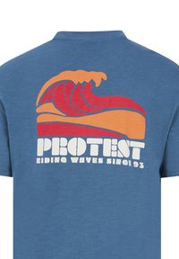 Mėlynas medvilninis marškinėlis su raudonomis ir oranžinėmis stilizuotomis bangomis bei užrašu "PROTEST RIDING WAVES SINCE 93" baltomis raidėmis.