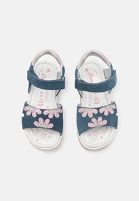 Sandalias de ante azul con acentos florales brillantes en rosa, correas ajustables y una plantilla suave plateada con patrones de estrellas.