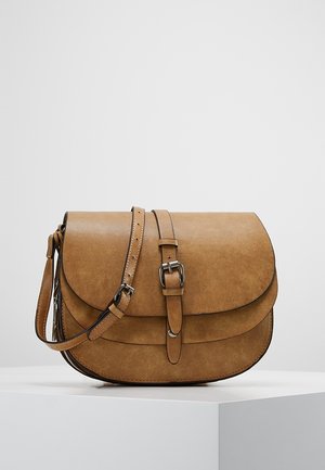 Sac bandoulière marron clair en simili cuir. Il présente un rabat arrondi, une bandoulière ajustable et un détail de boucle en métal. Texture lisse avec des coutures.