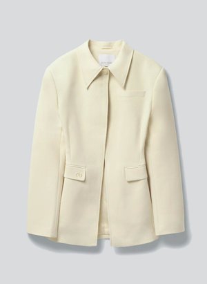 Κρεμ σακάκι με ραφές κατάλληλο για κοστούμι, με γιακά τύπου notch, κρυφή εμπρός κλείσιμο, δύο πίσω τσέπες με καπάκι και λεπτομέρεια κουμπιού, και μία στήθη τσέπη με σκέπαστρο.