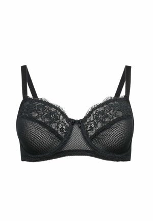 Donna vista da dietro che indossa un reggiseno nero con spalline regolabili e chiusura a gancetto, capelli raccolti in una coda di cavallo.