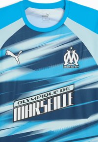Puma sportstrøje i gradient blå nuancer, med rund krave, et logo og teksten "Olympique de Marseille" i fed hvid skrift.