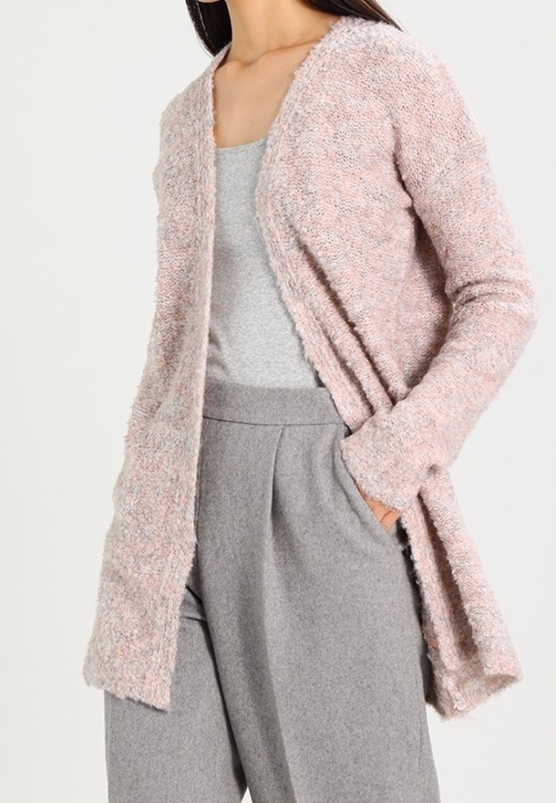 Cardigan rosa chiaro e testurizzato con apertura frontale, maniche lunghe e vestibilità comoda, abbinato a una maglietta grigia e pantaloni grigi.