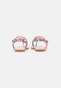 Sandalias con estampado floral y tiras en rosa, azul y verde. Suela plana con base beige y detalles en dorado. Diseño con talón abierto.