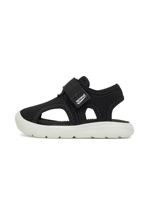 Sort åndbar mesh-sandal med hvid fleksibel sål og justerbar velcrolukning på hvid baggrund.