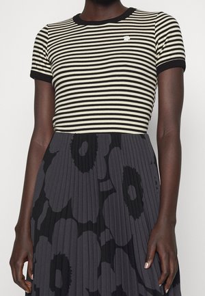 Czarny i kremowy top w paski z krótkim rękawem i żebrowanym dekoltem, w połączeniu z plisowaną szarą spódnicą z ciemnym kwiatowym wzorem.