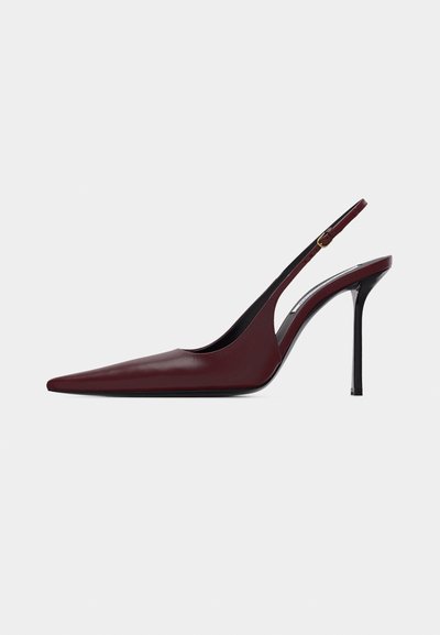 Μπορντό δερμάτινη γόβα με μύτη, λουράκι slingback, λεπτό μαύρο τακούνι στιλέτο και ρυθμιζόμενο χρυσό κούμπωμα.