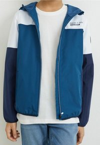 Modrá sportovní bunda s bílými a námořnickými akcenty, se zipem vpředu, kapucí a logem "BREAK IT DOW" na hrudi. Obsahuje elastické manžety.
