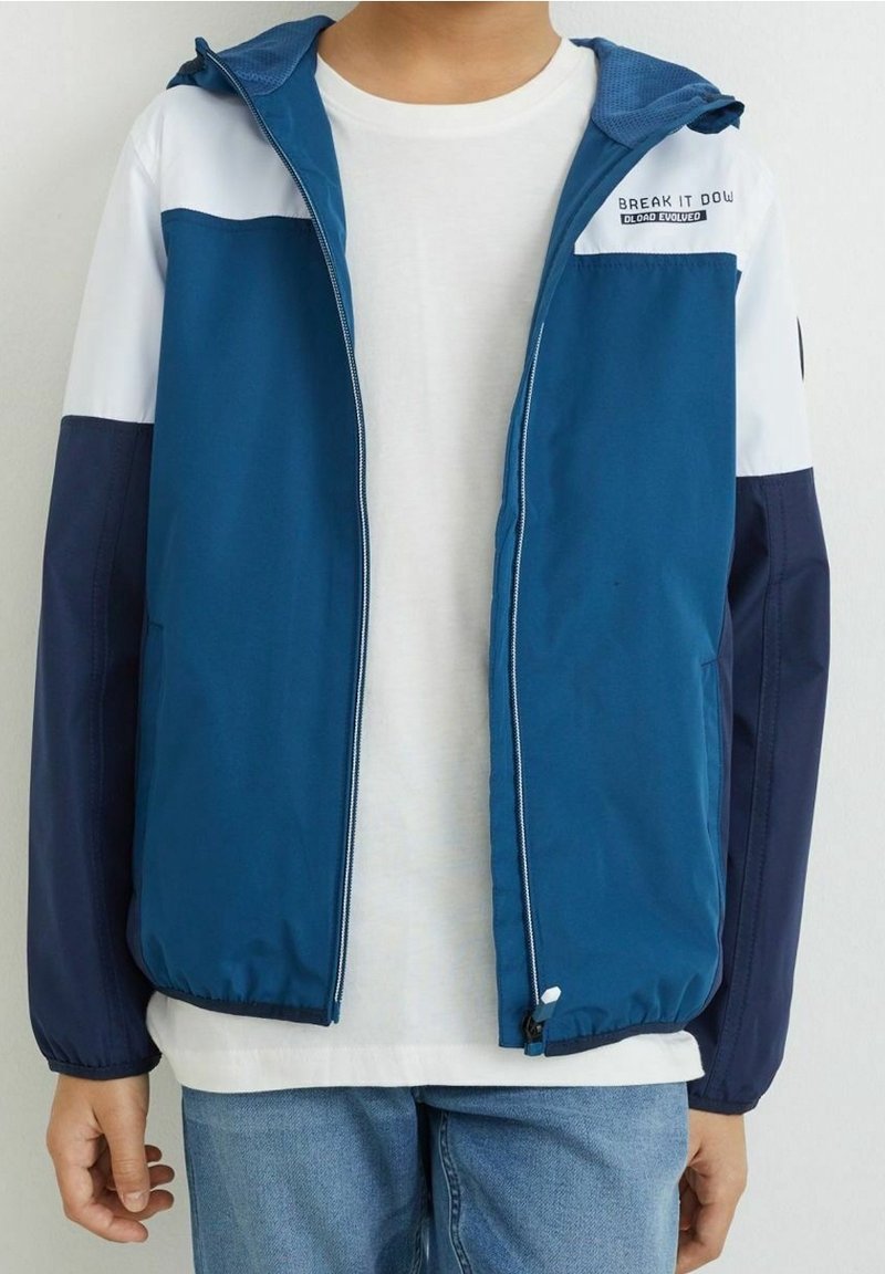 Modrá sportovní bunda s bílými a námořnickými akcenty, se zipem vpředu, kapucí a logem "BREAK IT DOW" na hrudi. Obsahuje elastické manžety.