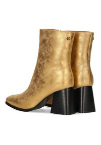 Botas de tobillo doradas con un acabado de cuero metálico, punta redonda y tacones de bloque negros texturizados. Presenta un pequeño logo en la parte trasera.