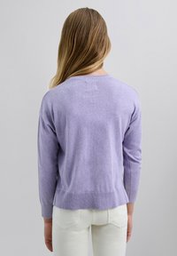 Suéter de punto morado claro con cuello redondo, dobladillo acanalado y mangas. Textura suave, ajuste casual y parte trasera ligeramente más larga.