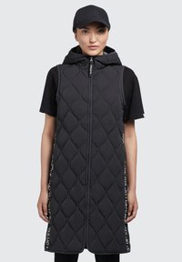 Schwarze steppierte ärmellose Weste mit Kapuze, Frontreißverschluss und vertikaler Seitentextgestaltung. Glatte Textur und elongated Design.