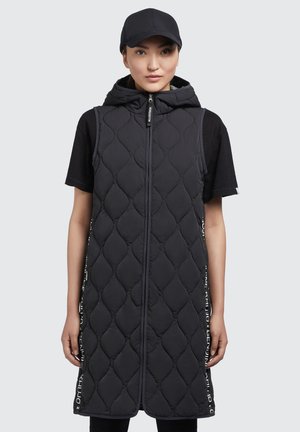 Black quilted sleeveless vest with a hood, front zipper, and vertical side text detailing. Smooth texture and elongated design.