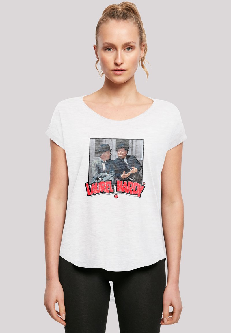 Weißes T-Shirt mit kurzen Ärmeln, das einen Vintage-Grafikdruck von Laurel und Hardy zeigt, mit roter und schwarzer Schrift unter dem Bild.