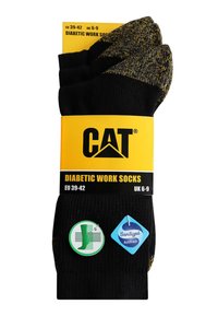 Chaussettes de travail diabétiques en noir avec un motif texturé. Étiquette jaune avec des détails sur le produit et des symboles d'entretien. Taille UE 39-42, UK 6-9.