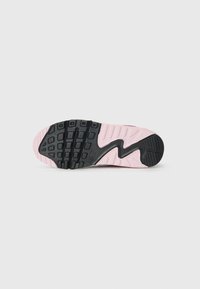Gumeni potplat Nike sportskih cipela s crnom teksturiranom gumom i ružičastim akcentima te valovitim dizajnom, pogodan za prianjanje i udobnost.