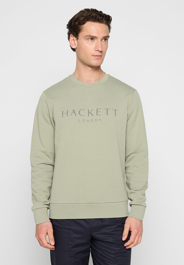 Sweatshirt vert clair avec texture côtelée, col rond et manches longues. Présente un logo imprimé gris "HACKETT LONDON" sur la poitrine.