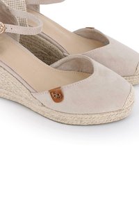 Sandalias de cuña de esparto de ante beige con punta redondeada, plantilla de yute trenzado y un pequeño acento de logo marrón en la correa lateral.