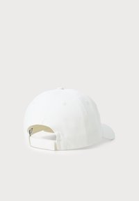 White cotton cap with a curved brim, adjustable strap at the back, and six-panel construction. Features ventilation holes for breathability.