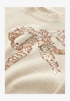 Bežs adīts džemperis ar lielu rozā zelta spīguļu loku dizainu, ar mīkstu tekstūru un ribinātu kakla izgriezumu.