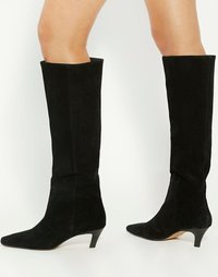 Bottes noires en suède montant jusqu'au genou, à bout pointu et petit talon empilé, avec une texture lisse et une silhouette propre et élégante.