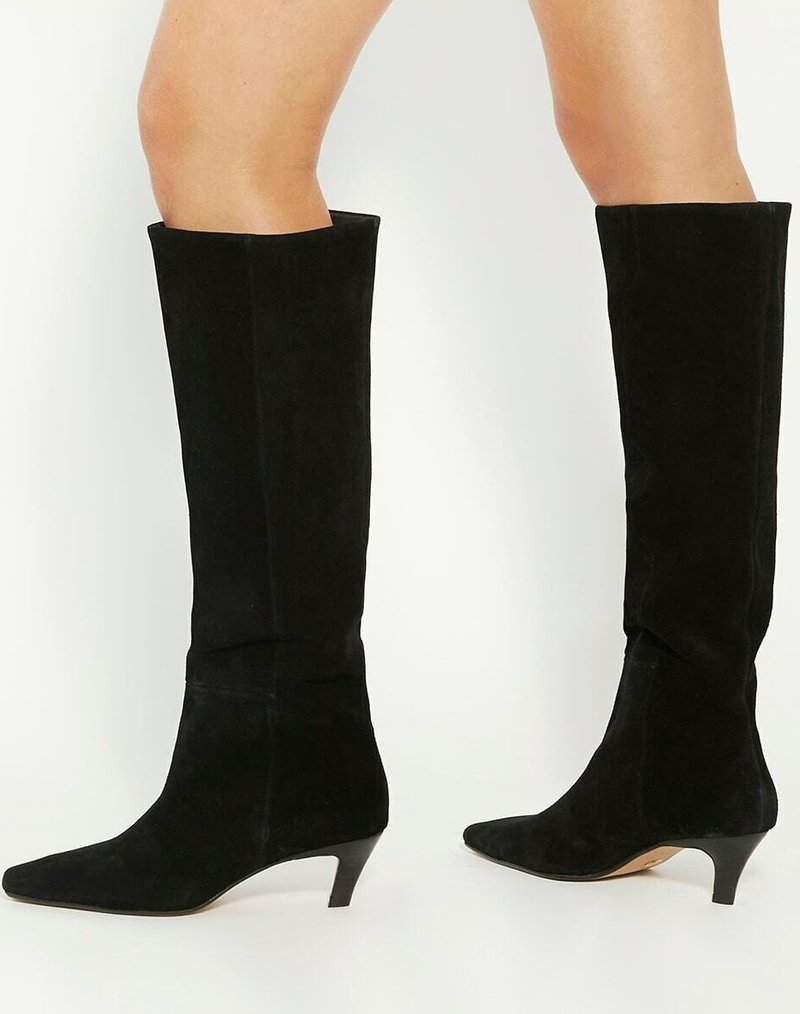 Bottes noires en suède montant jusqu'au genou, à bout pointu et petit talon empilé, avec une texture lisse et une silhouette propre et élégante.