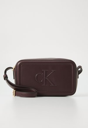 Bordeaux leren schoudertas met reliëf "cK" logo, rechthoekige vorm, afneembare strap en een gladde textuur. Gouden hardware accenten.