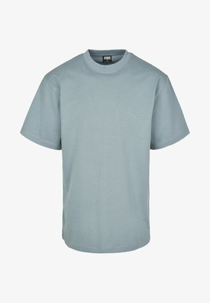 Világoskék pamut póló rövid ujjakkal, kerek nyakkivágással és laza fazonnal. Jellemzője a minimalista varrás és a látható grafikák vagy minták hiánya.