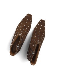 Bruine suede enkellaarsjes met zilveren studs die het oppervlak bedekken en een rits aan de zijkant, bovenaan weergegeven op een witte achtergrond.
