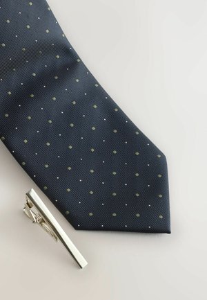 Maritimer Krawatte mit kleinen grünen und weißen Punkten aus strukturiertem Stoff. Inklusive einer silbernen Krawattenklammer mit schlankem Design.