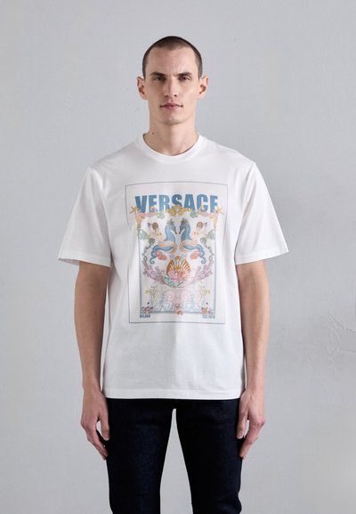 T-shirt bianca in cotone con una grafica colorata di cavallucci marini e conchiglie, con "VERSACE" in evidenza nella parte superiore.