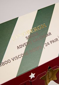 Advent calendar box for socks featuring green and white stripes, gold text, and a red base with star cutouts. Contains 24 pairs of bamboo viscose socks.