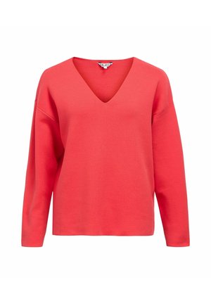 Maglione corallo con scollo a V, maniche lunghe e vestibilità rilassata. Realizzato in tessuto morbido con una texture liscia e senza motivi o accenti visibili.