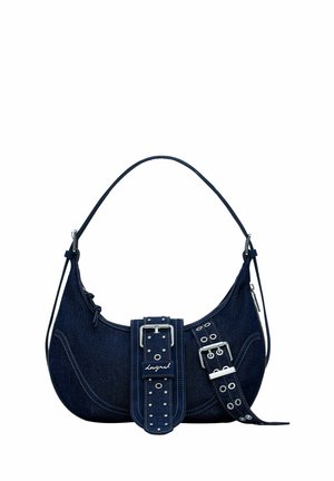 Mørkeblå denim skuldertaske med en buet top, sølv hardware, markant spænde detaljer og naglede stropper. Lynlåsrum synligt.