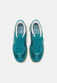 Teal sneakers with suede upper, mesh panels, white accents, and rubber soles. Laces and cushioned collar for comfort. Geometric-patterned insoles.