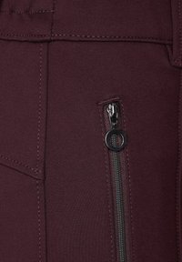 Bordeaux-housut, joissa on sivu vetoketjutasku. Kangas on sileä ja tiukka, ja se sisältää litteät saumat sekä tyylikkään, virtaviivaisen muotoilun.