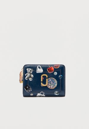 Marineblauwe leren portemonnee met kleurrijke patches, een logo van goudkleurig metaal en diverse decoratieve elementen zoals een teddybeer en fruit.