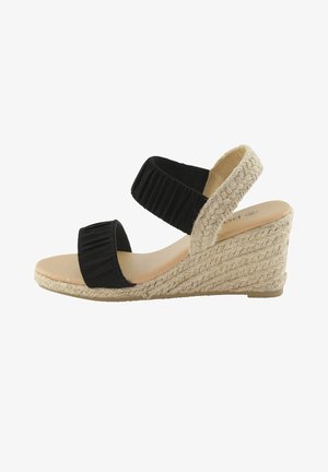 Sandale compensée noire avec deux lanières en tissu ribbé, talon en jute et semelle intérieure lisse beige. Design décontracté avec un talon de 10 cm.
