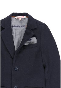 Blazer navy in tessuto strutturato, con rever a bottonatura, due tasche frontali e un fazzoletto coordinato nella tasca del petto con un motivo.