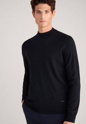 Marineblauer Strickpullover mit Rundhalsausschnitt, gerippten Bündchen und Saum. Hergestellt aus weichem Stoff mit glatter Textur und minimalem Branding-Detail Nähe des Saums.