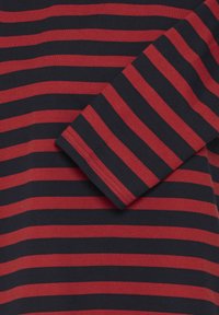 Red and navy striped long-sleeve shirt, made of soft cotton, featuring a round neckline and stitched hem on sleeves, with alternating wide stripes.