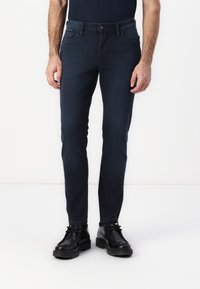 Dark blue slim-fit jeans made of denim, featuring belt loops, front and back pockets, with a smooth texture and minimalistic design.